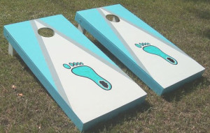 Carolina blue and white color combination of cornhole board along with Tar Heels foot icon in the middle